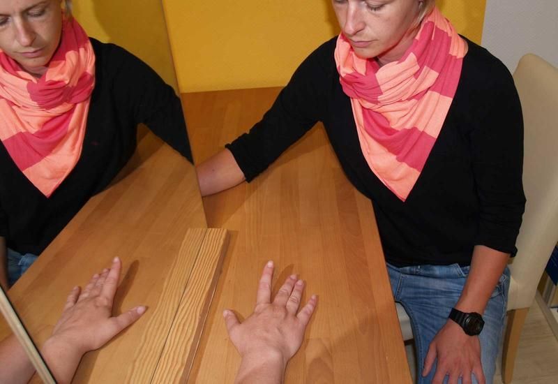 Eine Hand liegt parallel zu einem Spiegel